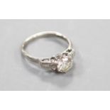 A white metal(stamped platinum) and single stone diamond ring with baguette and round cut diamond