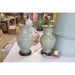 A pair of Chinese celadon glazed table lamps with green silk shades, height 33cm excluding light