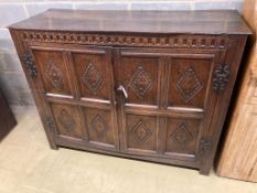 A 17th century carved and panelled oak cupboardenclosed by a pair of doors, length 139cm, depth