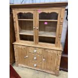 A Victorian pine dresserenclosed by a pair of glazed doors over cupboards and drawers, width 146cm,