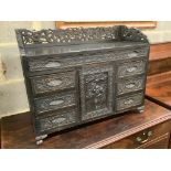 An Edwardian chinoiserie inspired ebonised oak table top cabinet, with cupboard and seven drawers,