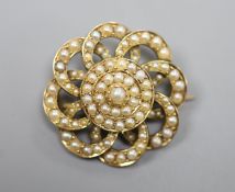 An early 20th century yellow metal and seed pearl set circular cluster brooch, 27mm,gross 9.1