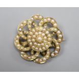 An early 20th century yellow metal and seed pearl set circular cluster brooch, 27mm,gross 9.1