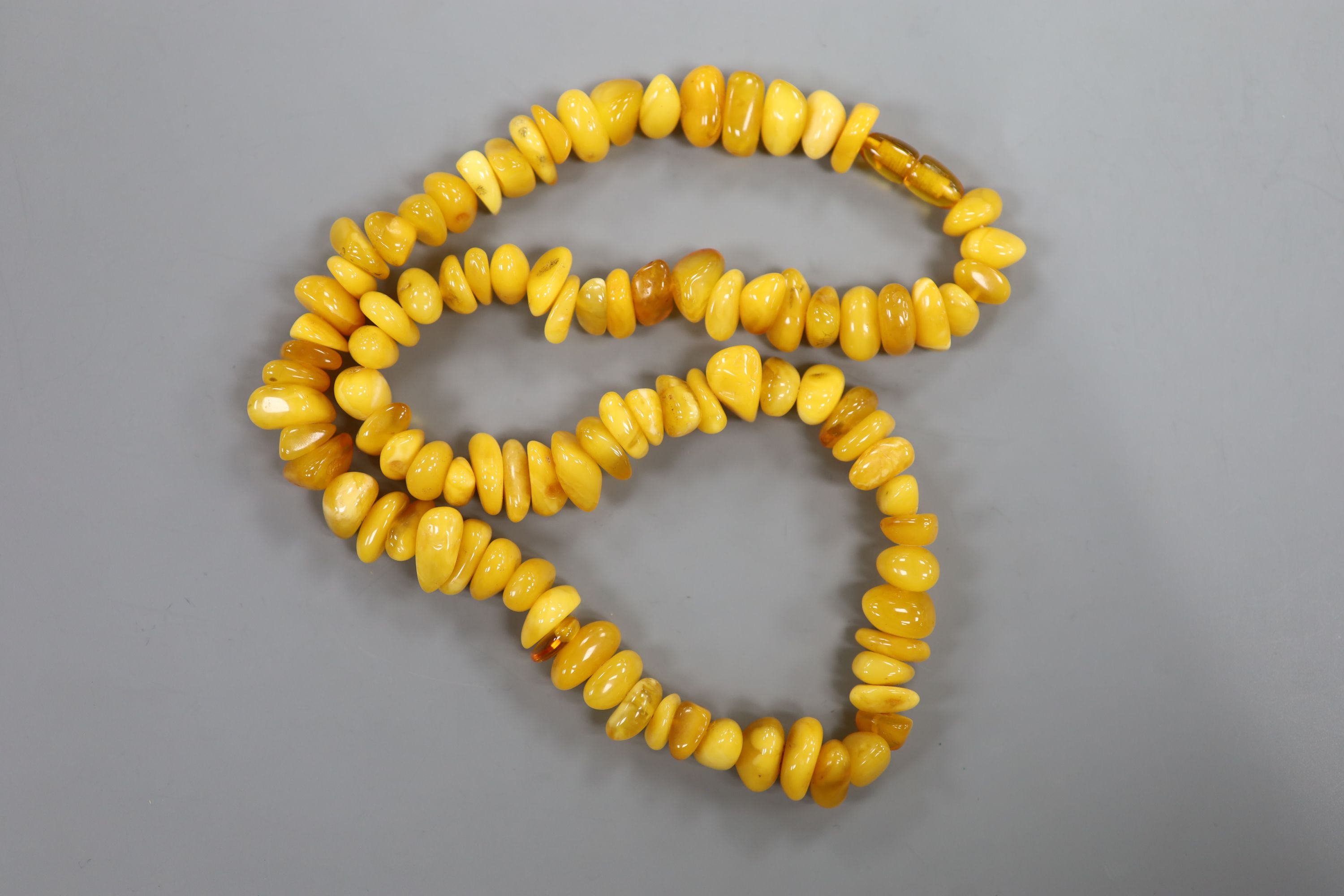 A single strand amber pebble necklace, approximately 66cm, gross weight 75 grams. - Image 3 of 3