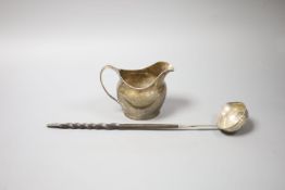 A George III silver cream jug, London, 1802 (a.f.)9.5cm and a 19th century white metal toddy ladle,