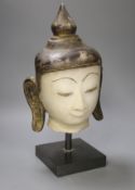 An 18th century Burmese white marble Shan-Style Buddha’s head, on stand, bought in 1995 in Burma or