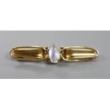 An early 20th century Arts & Crafts 9ct and cabochon moonstone set bar brooch,