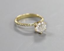 A modern 14kt yellow metal and single stone diamond ring, with diamond chip set shoulders,size L,