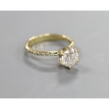 A modern 14kt yellow metal and single stone diamond ring, with diamond chip set shoulders,size L,