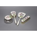 A four-piece silver plated and enamel dressing table set