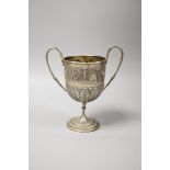 An embossed Indian white metal two handled pedestal trophy cup, height 22.2cm, 12.5oz.