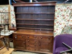 An early 19th century oak dresser with boarded rack, length 174cm, depth 48cm, height 210cm