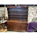 An early 19th century oak dresser with boarded rack, length 174cm, depth 48cm, height 210cm