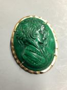 An oval malachite cameo brooch-cum-pendant, relief-carved with the profile portrait of a young