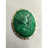 An oval malachite cameo brooch-cum-pendant, relief-carved with the profile portrait of a young