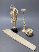 A carved Chinese ball on stand, a brise fan and a Japanese carved figure