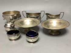 A pair of George V silver pedestal nut dishes, a small silver bowl with lion mask handles, a silver