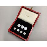 A cased set of seven sterling white metal buttons (two sizes), five bearing the stamp 'Cartier',