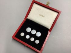 A cased set of seven sterling white metal buttons (two sizes), five bearing the stamp 'Cartier',