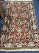 A Qum silk prayer rug,the red field with mihrab, palmettes, floral trellis, floral and foliate
