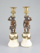 A pair of 19th century bronze and ormolu figural candlesticks,with kneeling figures raising urns,