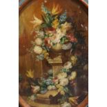 19th century Italian SchoolStill life of flowers in an urn upon a pedestal, a wall and trees