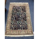 A Qum 'Tree of Life' part silk rug,the indigo field decorated with deer, rabbits, birds, flowers