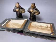 A pair of painted spelter monk spill vases,17cm, and a postcard album
