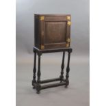 An early 18th century European japanned cabinet on stand,the single panelled door with gilt brass