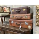 Three vintage leather suitcases, largest width 76cm, depth 45cm