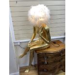 A large gilded seated female mannequin with illuminating feather shade, height 130cm