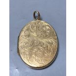 A 1960's engraved 9ct gold mounted oval pendant locket,41mm, gross 14.5 grams.