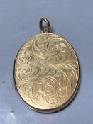 A 1960's engraved 9ct gold mounted oval pendant locket,41mm, gross 14.5 grams.