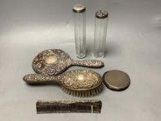 Two silver-topped narrow cylindrical toilet bottles, a silver backed-hand mirror and matching