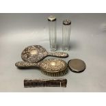 Two silver-topped narrow cylindrical toilet bottles, a silver backed-hand mirror and matching