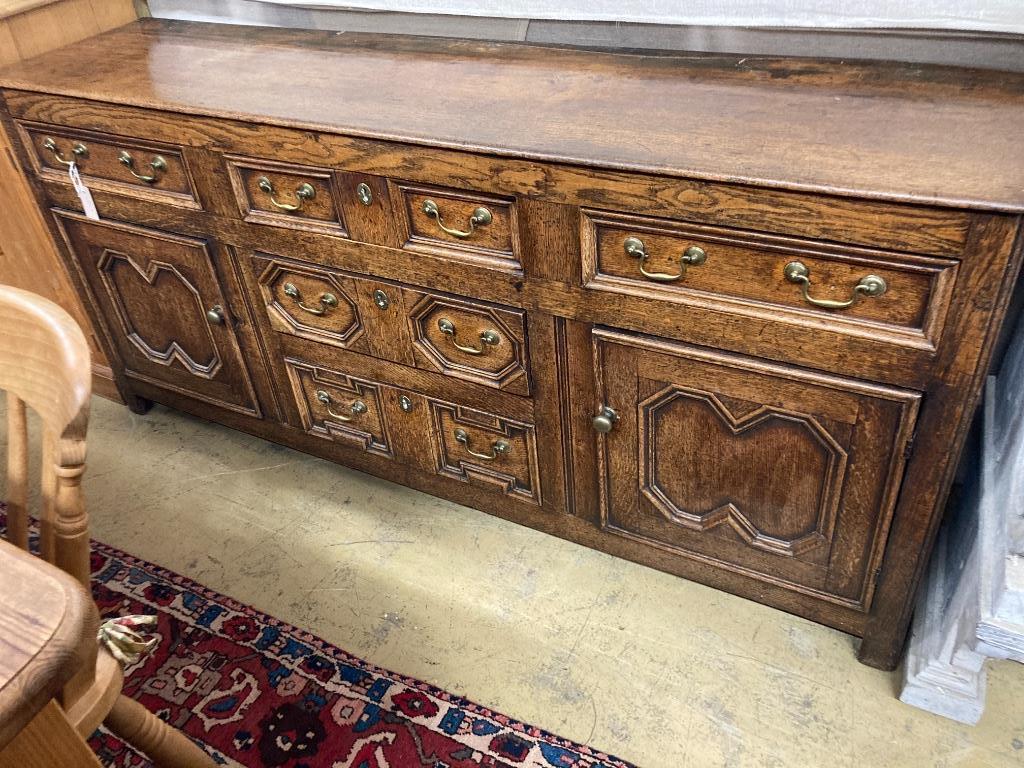 An early 18th century oak low dresser, with a geometric block mounted front, length 184cm, depth