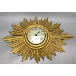 A giltwood sunburst wall clock, length 60cm