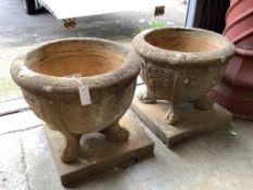 A pair of 19th century circular reconstituted stone garden planters on square plinth bases,