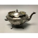 A late Victorian small silver teapot, of oval twelve-sided formon outswept paw feet, having raised