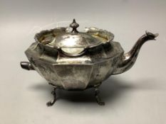 A late Victorian small silver teapot, of oval twelve-sided formon outswept paw feet, having raised