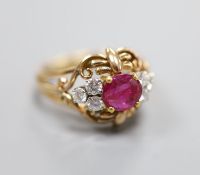 A stylish yellow metal, ruby and diamond set cluster ring, with single round cut ruby(crack),