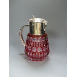 A large cranberry overlay cut glass lemonade jug with plated cover and handle, with removable ice