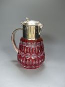 A large cranberry overlay cut glass lemonade jug with plated cover and handle, with removable ice