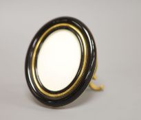 A Must de Cartier black lacquered and gilt oval easel photograph frame, length 9cm