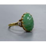 A jade and diamond dress ring, 18ct yellow gold setting,the oval cabochon jade flanked by two small