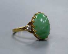 A jade and diamond dress ring, 18ct yellow gold setting,the oval cabochon jade flanked by two small
