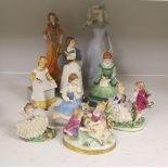 A German porcelain group of two children by a tree stump, on rocky base, two 'crinoline' figures