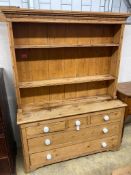 A Victorian pine dresserhaving boarded plate rack over three short drawers and three graduated long