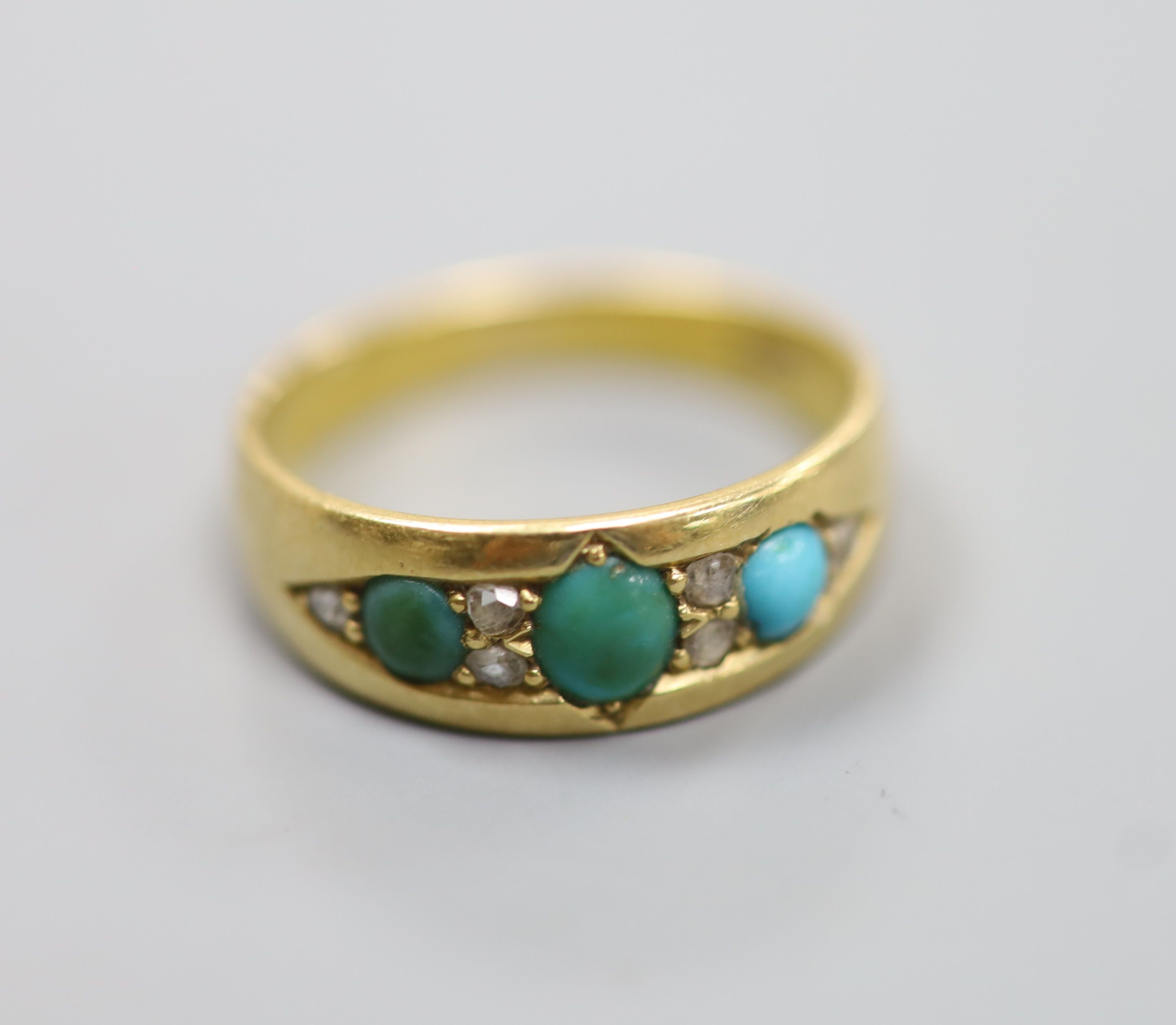 An early 20th century 18ct, three stone turquoise and six stone diamond chip set ring, size M/N,