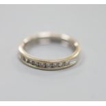 A modern 18ct white gold (worn) and nine stone channel set diamond half eternity ring, size P,gross